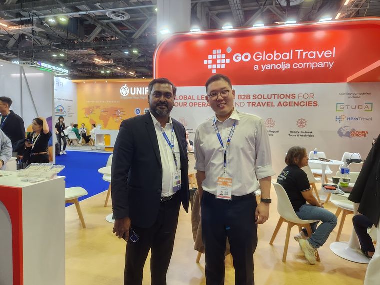 Two people on the exhibition floor at Travel Tech Asia 2025 in Singapore