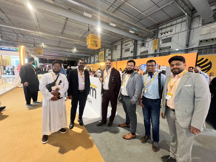 Group photograph beside the WTM Spotlight Riyadh signage inside the exhibition hall